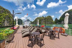 a deck of a boat with tables and chairs at Ngọc Bích Luxury in Cat Ba
