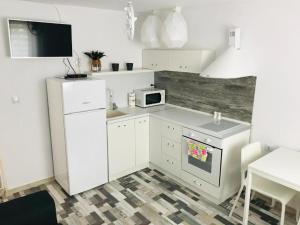 a white kitchen with a sink and a microwave at Вила ОмниЯ in Chernomorets