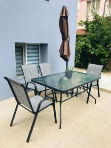 チェルノモレツにあるВила ОмниЯのパティオに置かれたテーブルと椅子、そして傘
