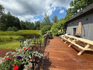 a wooden deck with benches and flowers next to a building at Misas loki in Cena