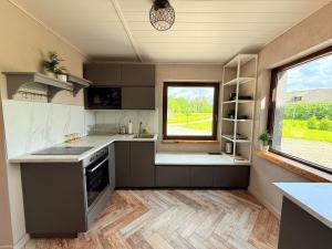 a kitchen with gray cabinets and a large window at Misas loki in Cena