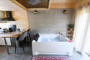 a bath tub in a kitchen with a table and a tableablish at Le Filet Tendu in Marmoutier