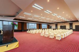 a large room with white chairs and a podium in it at Sunbeam Hotel Pattaya in Pattaya +142 photos