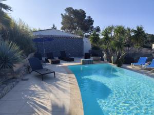 a swimming pool with blue chairs and a patio at Mimosas - villa in Fréjus