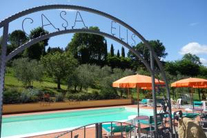 a pool with chairs and umbrellas in front of a resort at Casa Elisa in Montaione