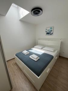 a bedroom with a bed with two towels on it at Apartment Bokanjac Free Covered Parking & Quiet Neighborhood in Zadar
