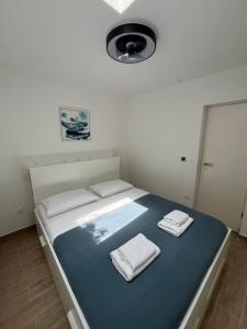 a bedroom with a bed with two towels on it at Apartment Bokanjac Free Covered Parking & Quiet Neighborhood in Zadar