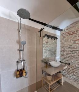 a bathroom with a sink and a brick wall at Les Ametlles in Masarach +41 photos