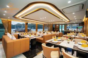 a restaurant on a yacht with tables and chairs at Ngọc Bích Luxury in Cat Ba
