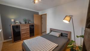 Un dormitorio con una cama, una cómoda y una lámpara. en Gelbach Living, en Montabaur