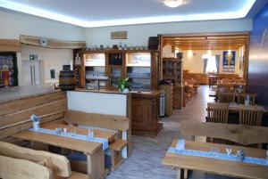 un restaurant avec des tables et des bancs en bois dans l'établissement Hotel Stangl, à Hamm