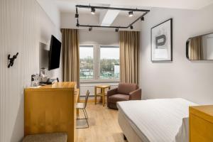 a hotel room with a bed and a desk and a chair at Original Sokos Hotel Wiklund in Turku