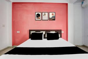a bedroom with a large bed with a red wall at Hotel O Purani Haveli in Phanda +21 photos