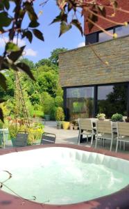 a hot tub in the backyard of a house at fredhousedurbuy in Durbuy