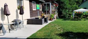 a patio with chairs and umbrellas next to a building at Chata pod lesom in Modra