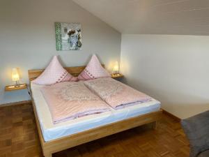 a bedroom with a bed with pink pillows at Apartment-Ferienwohnung Penzkofer in Zandt