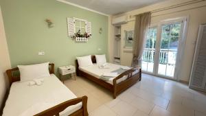 una camera da letto con due letti e una grande finestra di Orea Boutique Studios a Asprovalta Altre 73 foto