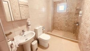 a white bathroom with a toilet and a sink at Orea Boutique Studios in Asprovalta +75 photos