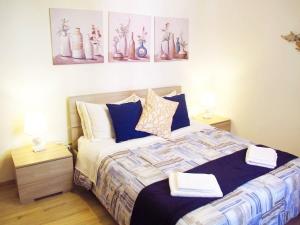 a bedroom with a bed with two night stands and two lamps at Blue House Termini-Colosseo in Rome