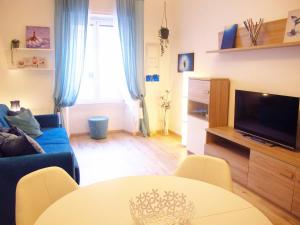 a living room with a blue couch and a table at Blue House Termini-Colosseo in Rome