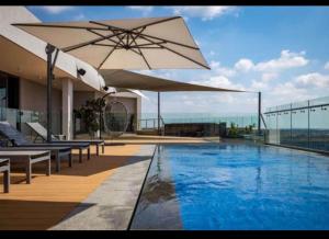 a swimming pool with an umbrella on top of a building at Menlyn Main Apartments Trilogy in Pretoria