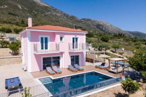 a villa with a swimming pool and a house at Villa Roz by Villa Plus in Plateies