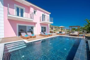a villa with a swimming pool and a house at Villa Roz by Villa Plus in Plateies