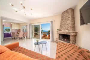 a living room with a couch and a fireplace at Villa Roz by Villa Plus in Plateies