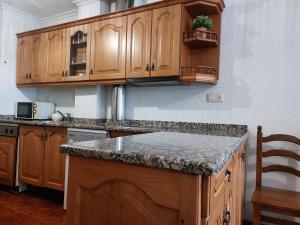 a kitchen with wooden cabinets and a granite counter top at Céntrico apartamento en el casco antiguo de Potes in Potes