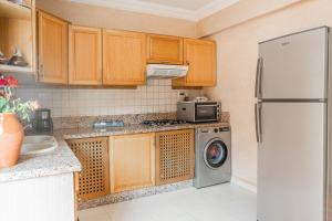 a kitchen with a refrigerator and a washing machine at Luxury Villa Ocean View with pool in Tiguert