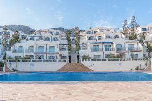 a large white apartment building with a swimming pool at Luxury Villa Ocean View with pool in Tiguert