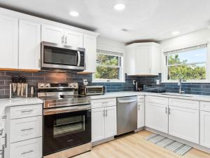 a kitchen with white cabinets and stainless steel appliances at 3041 - The Beach House in Southern Shores
