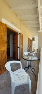 Habitación con mesa, sillas blancas y mesa. en Spiros Studios - Apartments, Ipsos, en Ýpsos