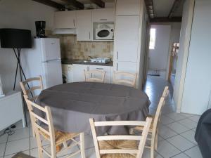 Una cocina con mesa y sillas y un refrigerador. en Les Flots Bleus Etage, en Biscarrosse-Plage 5 fotos más