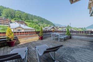 a balcony with a table and chairs on a roof at Lodge 4 Apartment 9- Snow and Trek - Morzine in Montriond