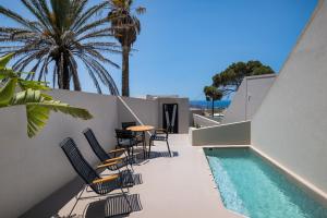 een terras met stoelen en een tafel en een zwembad bij Calissa Suites by Ananda in Pirgos