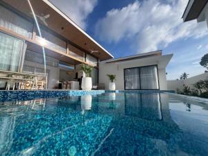 une piscine devant une maison dans l'établissement Villa White House - Chaweeng, à Ban Ko Khwan