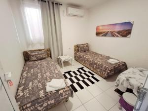 波德戈里察AS MONTENEGRO SUITES的有两张床和一张沙发的客厅