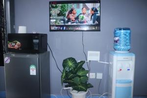 a tv hanging on a wall next to a refrigerator at The Loft & Found in Nairobi