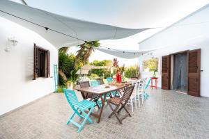 Un patio al aire libre con una mesa y sillas de madera. en Il Giardino Dei Gelsi Otranto, en Otranto