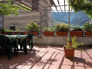 un patio con tavolo, sedie e piante in vaso di Casa David a Calci