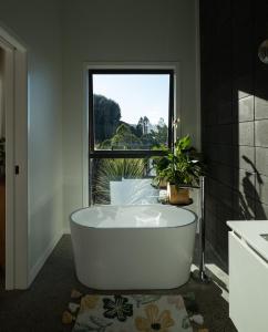 a bath tub in a bathroom with a window at Manu Heights Retreat, tranquil luxury, views and privacy in Dunedin
