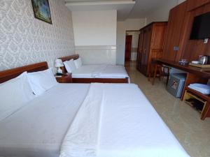 Postel nebo postele na pokoji v ubytování Kim Ngoc Khanh Hotel