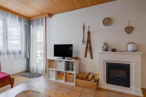 salon z telewizorem i kominkiem w obiekcie Apartment Gerlitzen Garden w mieście Treffen am Ossiacher See