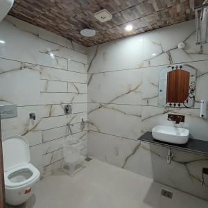 ダルハウジにあるHotel Dalhousie Hillsのトイレと洗面台を備えた白いバスルーム