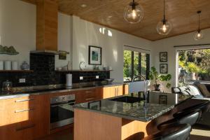 a kitchen with wooden cabinets and a black counter top at Manu Heights Retreat in Dunedin