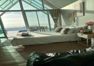 a bedroom with a large bed and a large window at Taara Montana Resort in Ban Huai Khai