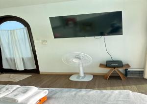 a bedroom with a fan and a tv on a wall at Taara Montana Resort in Ban Huai Khai