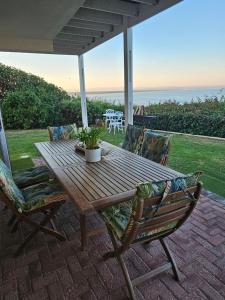 a wooden table and chairs on a patio at SEEMEEU in Jeffreys Bay