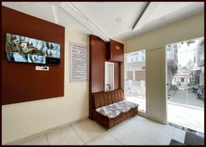a waiting room with a bench and a television at HOTEL G- RESIDENCY Near Shri Mahakaleshwar Jyotirlinga Temple - Railway Station Ujjian - Fully Air Conditioned And Spacious Room - Excellent Service Recommended in Ujjain +8 photos